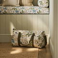 Sophie Allport botanicals style large picnic bag, and matching quilted picnic mat on a sunlit lawn.